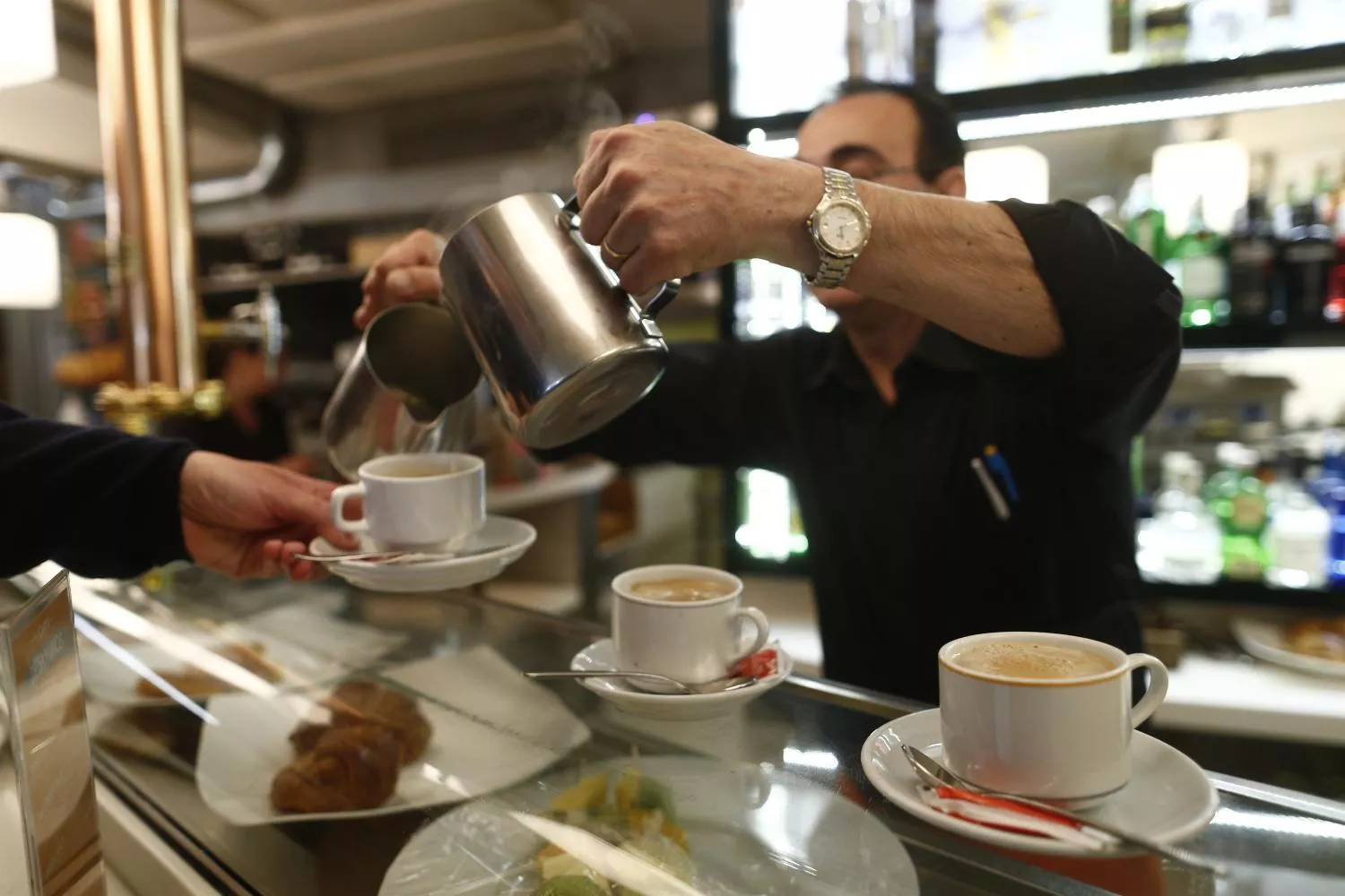 Un trabajador sirve cafés en un local de hostelería pequeño y de barrio / EUROPA PRESS