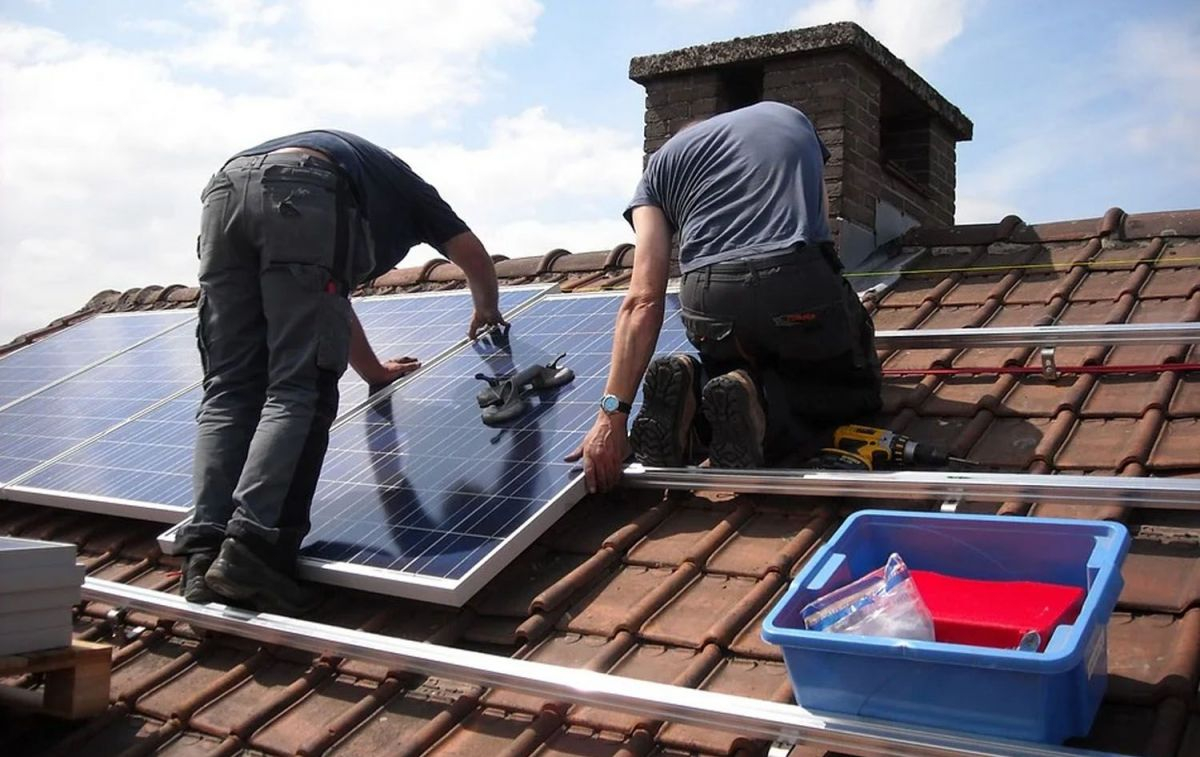 Unos operarios instalan placas solares en un edificio / PIXABAY