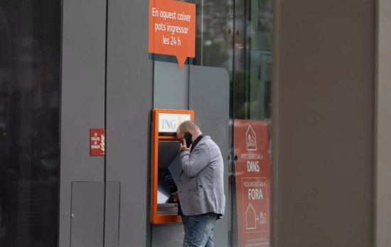 Una persona saca dinero en un cajero Una persona saca dinero en un cajero