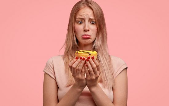 Una chica que mira un bollo y busca una técnica efectiva para adelgazar / FREEPIK Una chica que mira un bollo y busca una técnica efectiva para adelgazar / FREEPIK