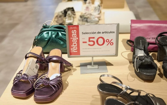 Un expositor de diferentes artículos con un cartel anunciando su descuento de rebajas, en El Corte I Un expositor de diferentes artículos con un cartel anunciando su descuento de rebajas, en El Corte I