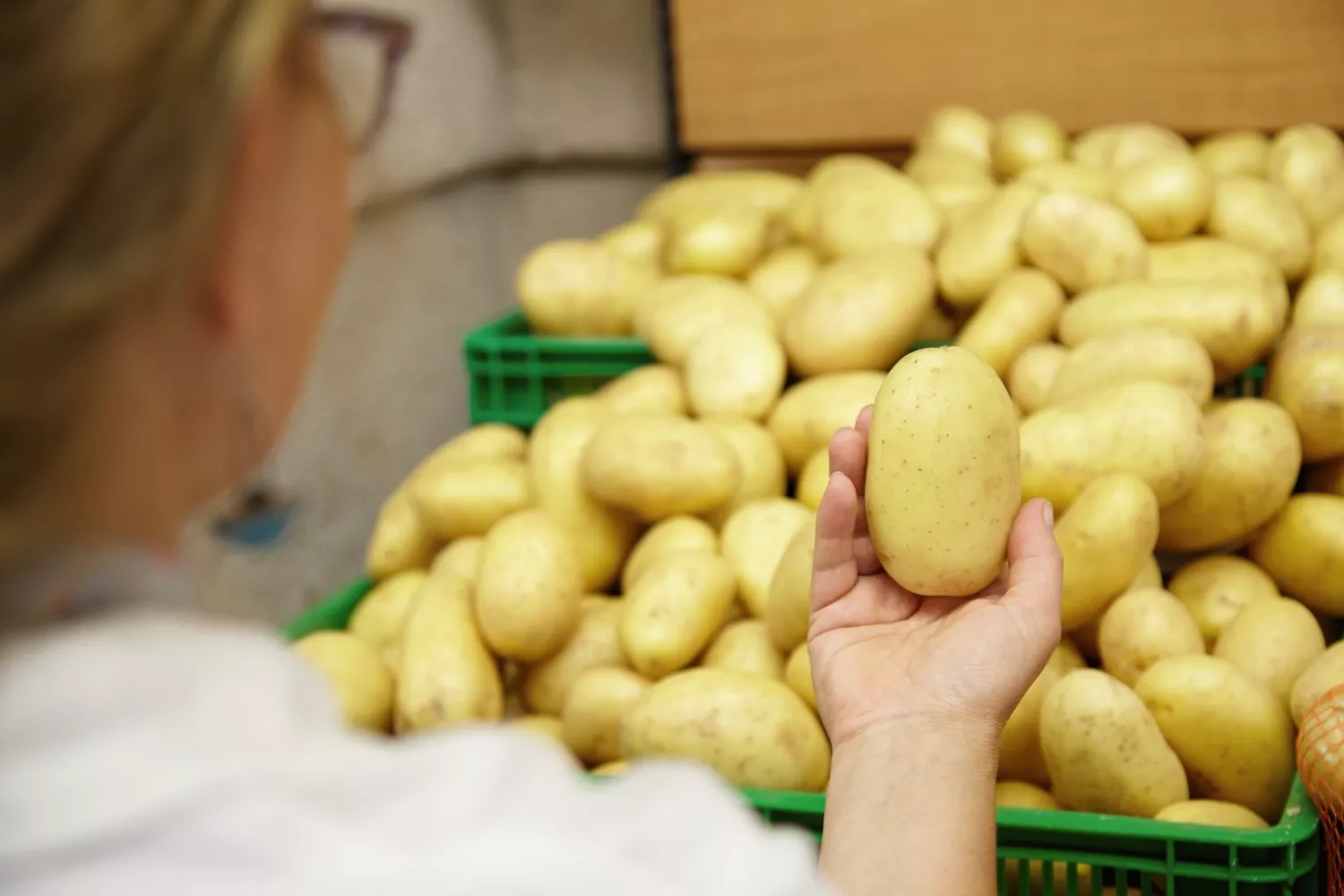Una clienta compra patatas en un supermercado