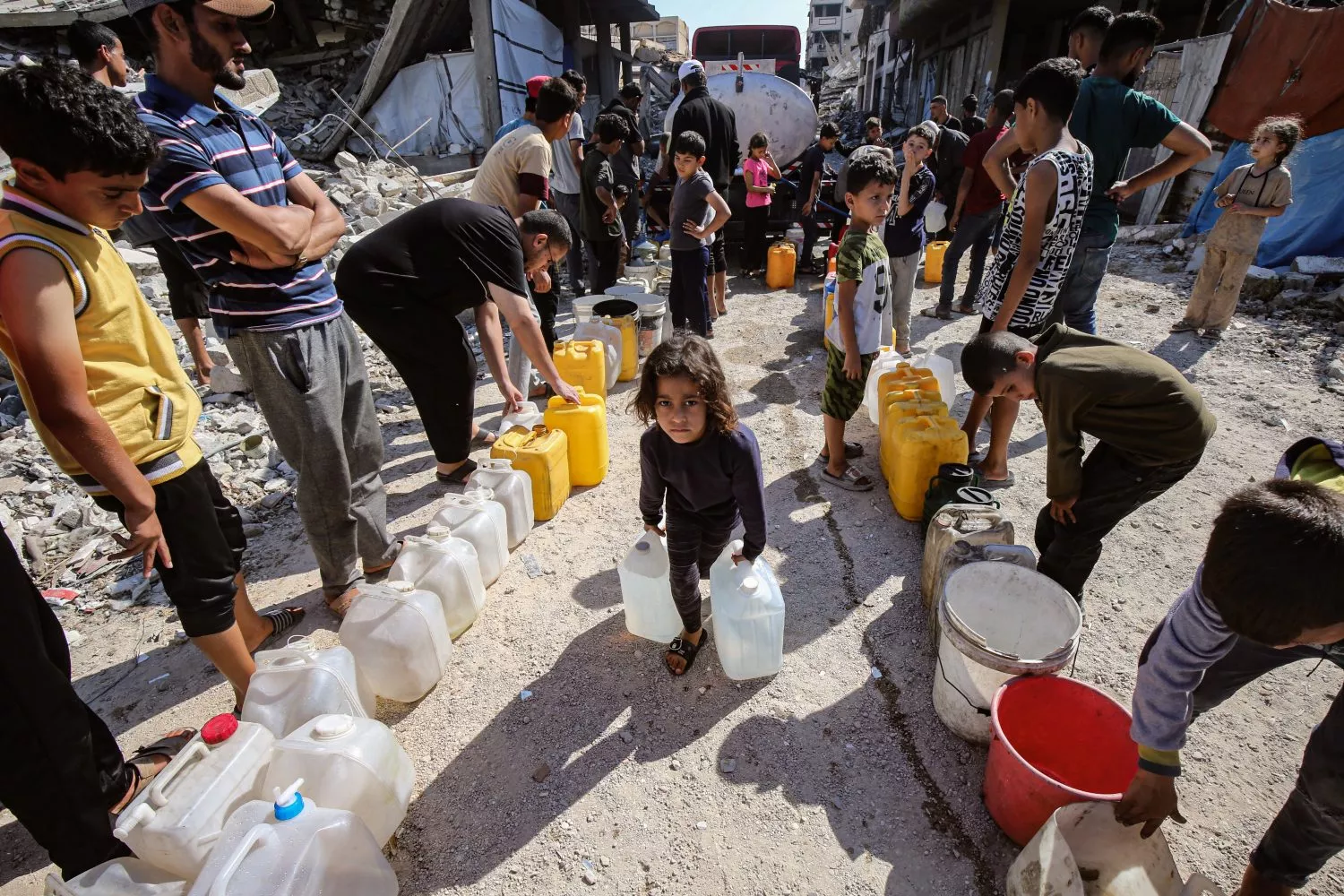 Niños palestinos cargan bidones llenos de agua distribuida por un camión cisterna en Gaza / Omar Ashtawy - EP