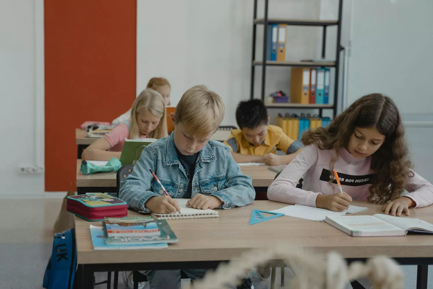Niños con material escolar en la escuela / PEXELS