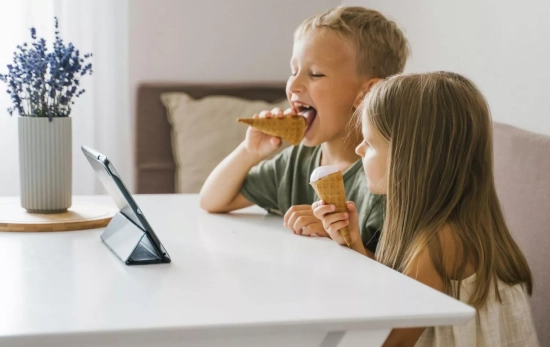 Dos niños miran una tablet Dos niños miran una tablet
