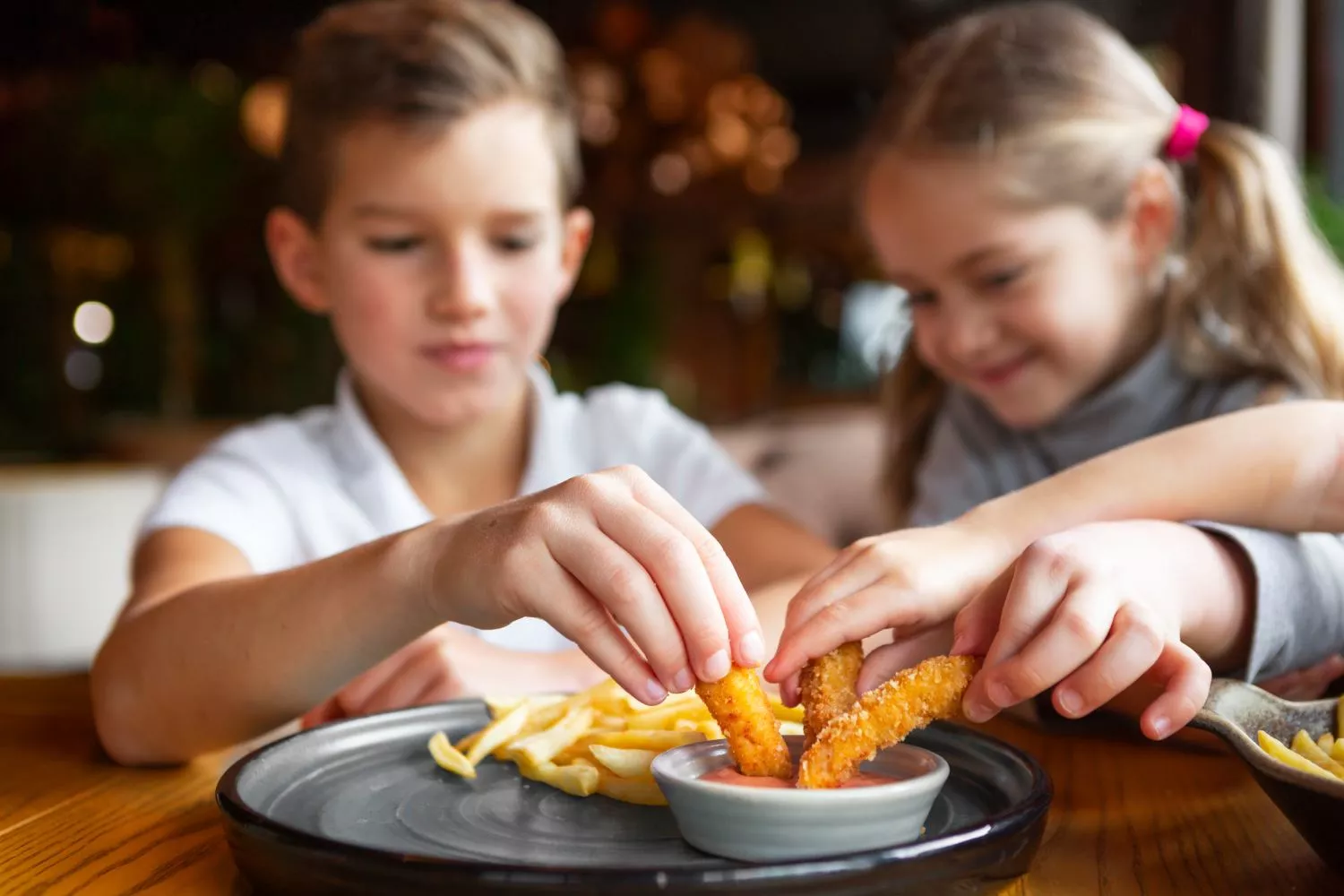 Varios niños comen alimentos ultraprocesados / FREEPIK