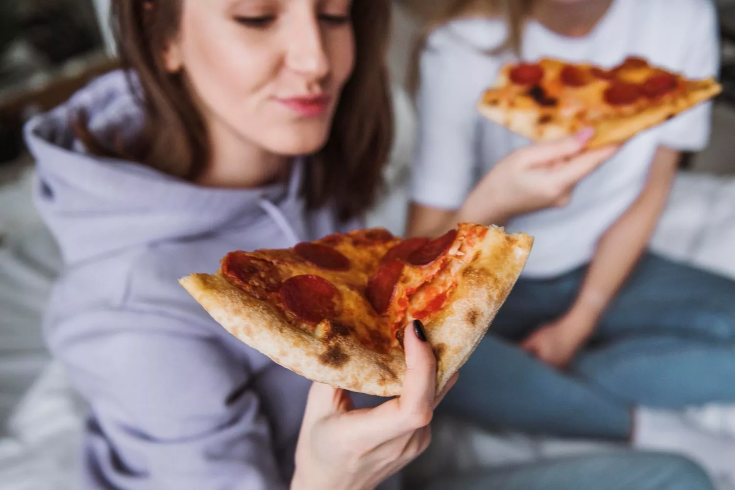 Dos amigos comen pizza / FREEPIK