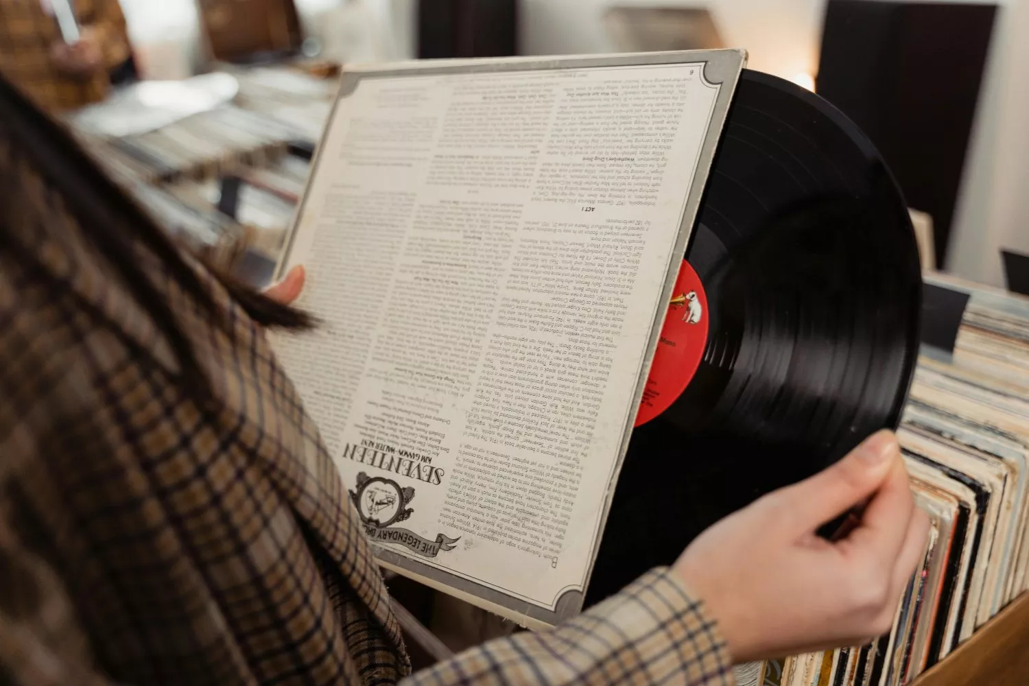 Una persona sostiene un vinilo en una tienda similar a Discos Revolver / PEXELS