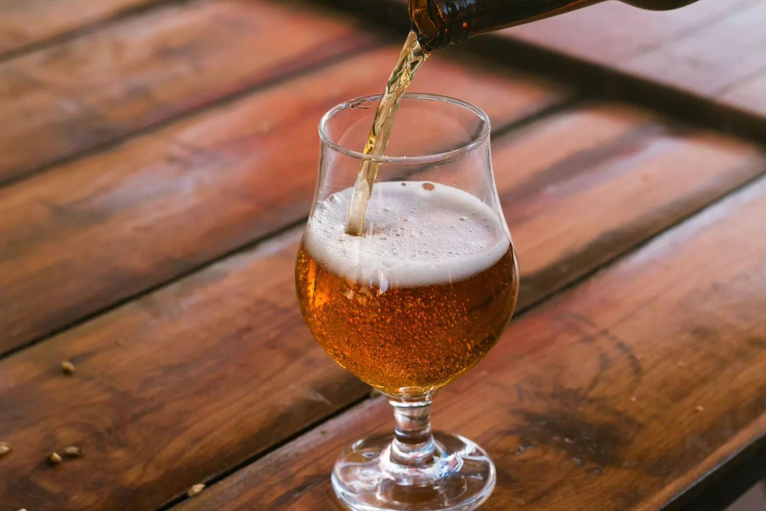 Una persona sirve una cerveza en una copa / UNSPLASH