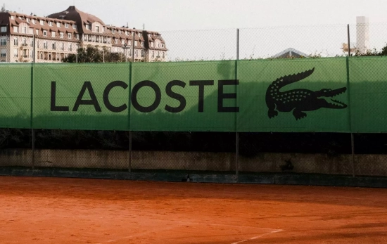 Logo de Lacoste junto a una pista de tenis Logo de Lacoste junto a una pista de tenis