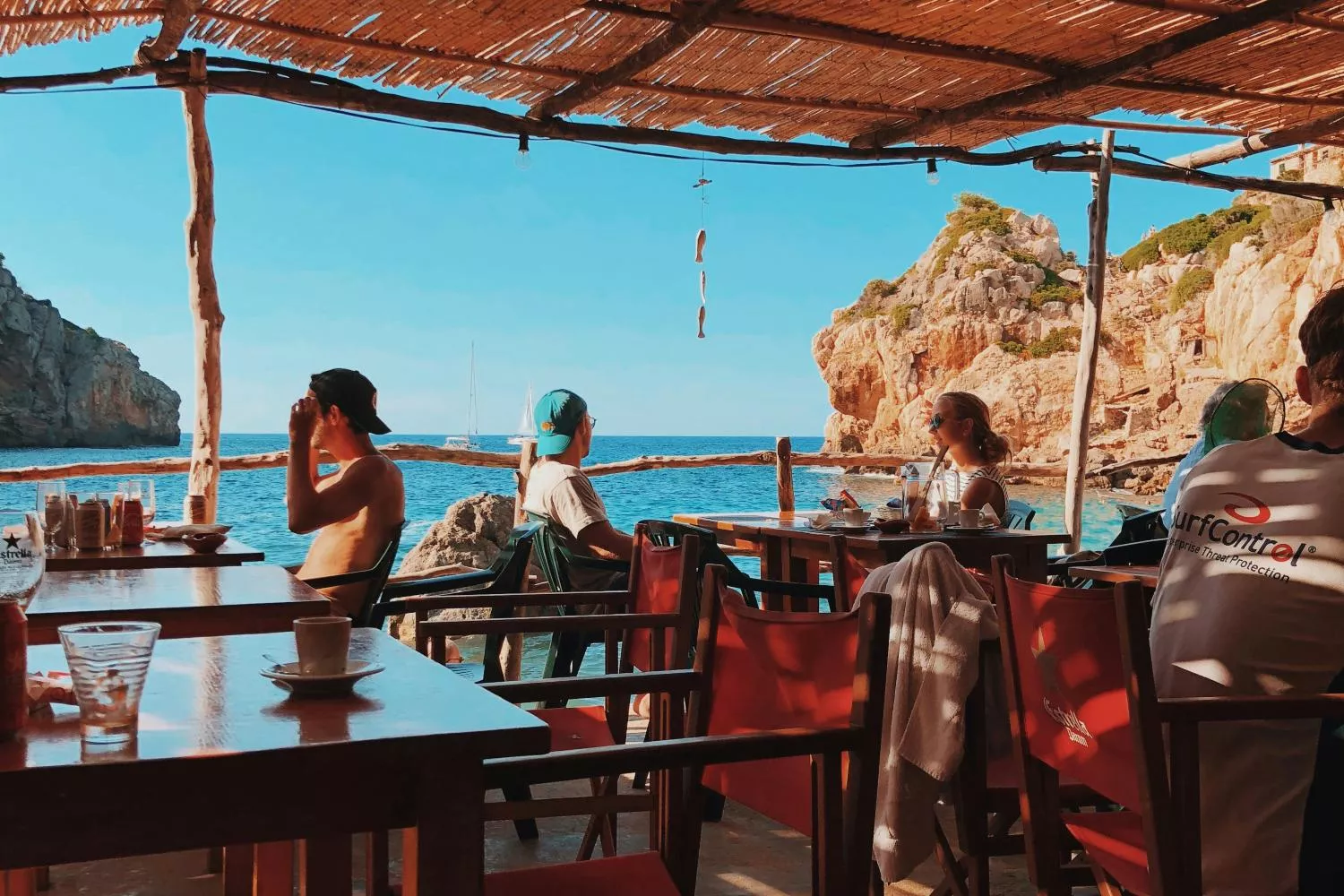 Varias personas disfrutan de sus vacaciones en un bar junto al mar