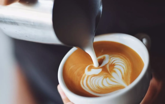 Una persona sirve una taza de café Una persona sirve una taza de café