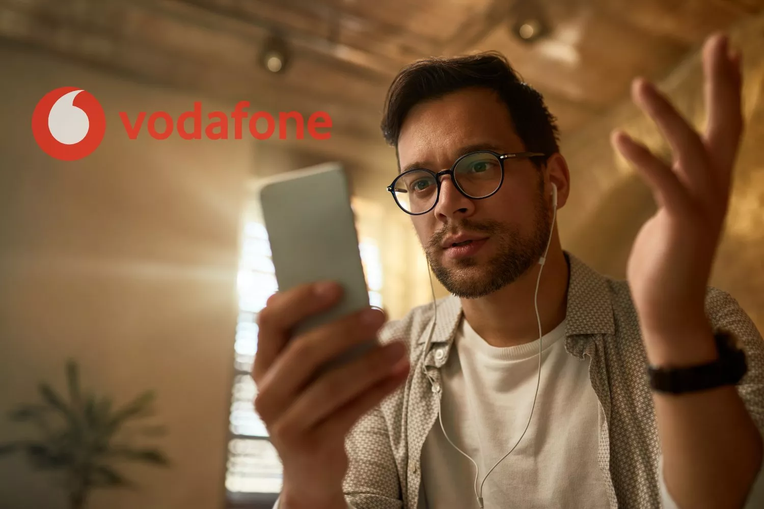 Un cliente de Vodafone mira su móvil / FOTOMONTAJE CONSUMIDOR GLOBAL