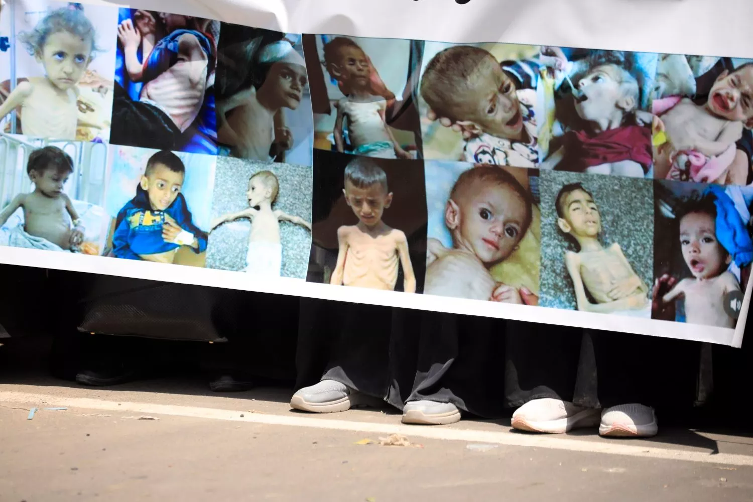 Manifestantes sostienen una pancarta que muestra a niños palestinos con desnutrición severa , en un año de récord de muertes por hambre / YAHYA ARHAB - EFE