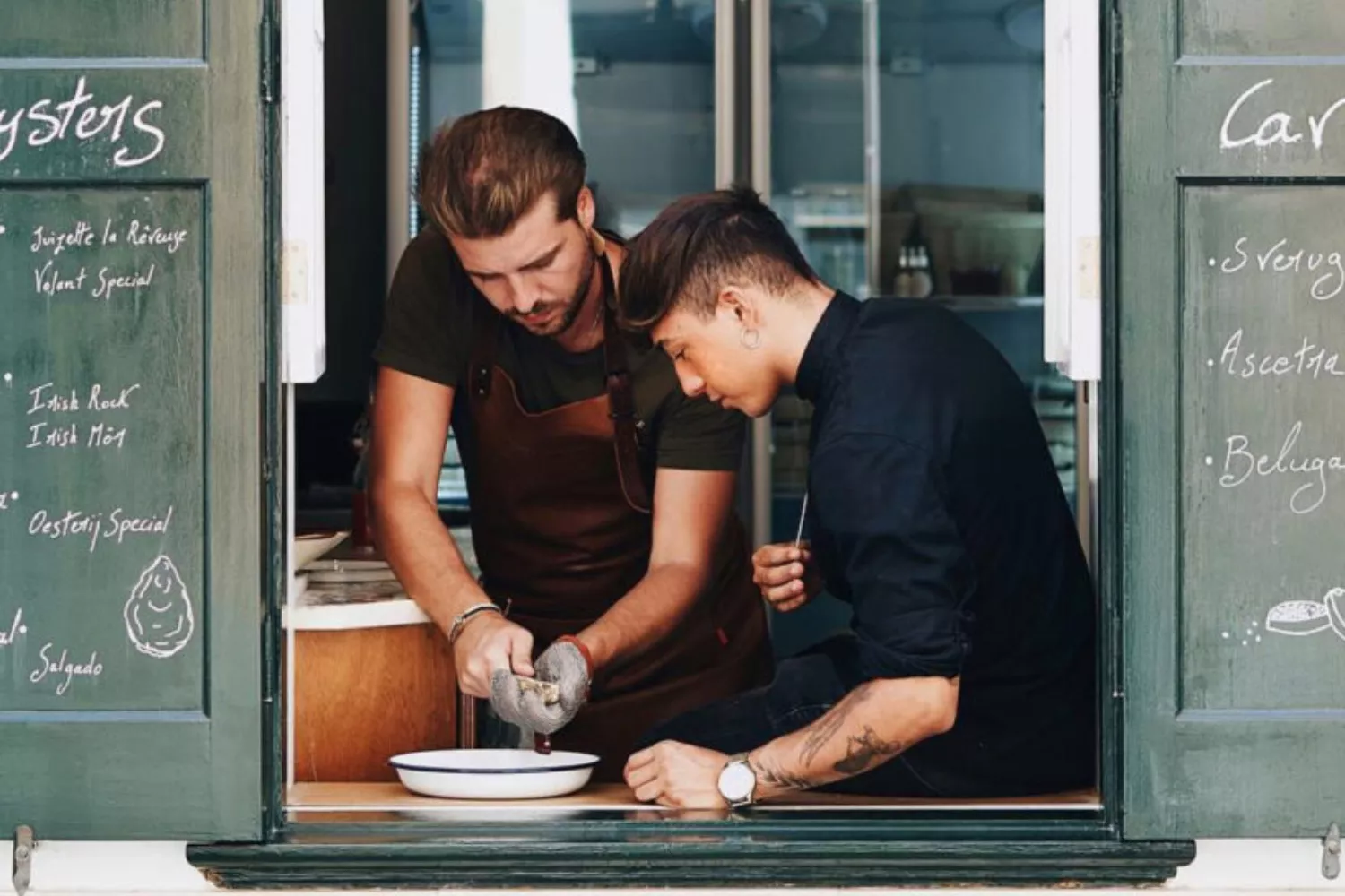 Tobias Kruijssen, uno de los fundadores, abre una ostra en presencia de uno de los empleados / OYSTERS MENORCA