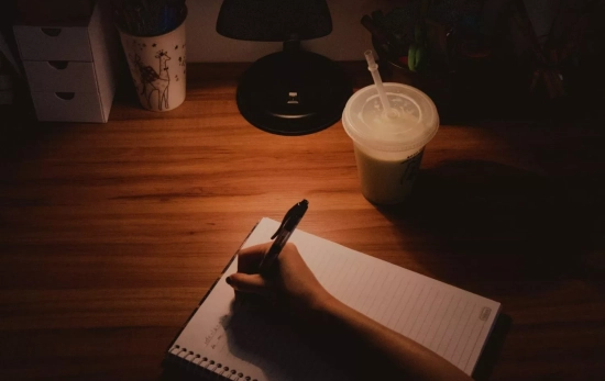 Una persona escribiendo en la quietud de la noche/ CANVA Una persona escribiendo en la quietud de la noche/ CANVA