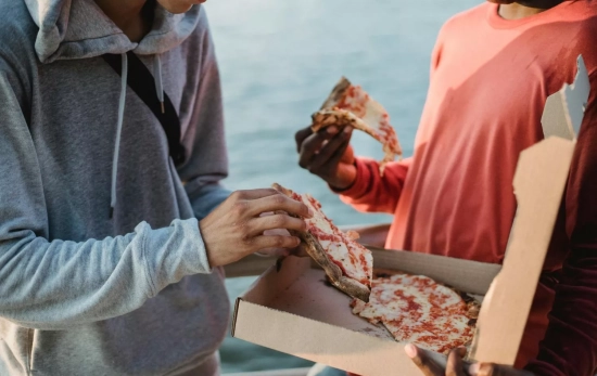 Dos personas comparten una pizza / PEXELS