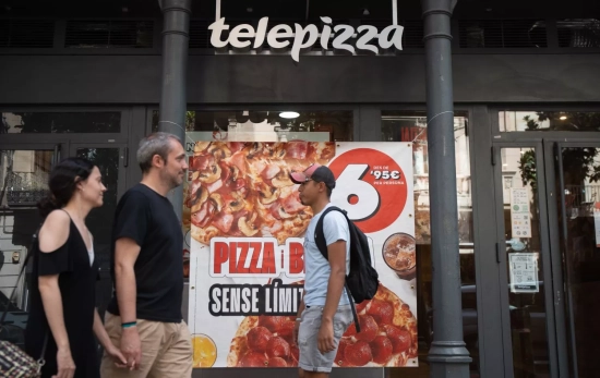 Varias personas pasan frente a un establecimiento de Telepizza / DAVID ZORRAKINO - EUROPA PRESS