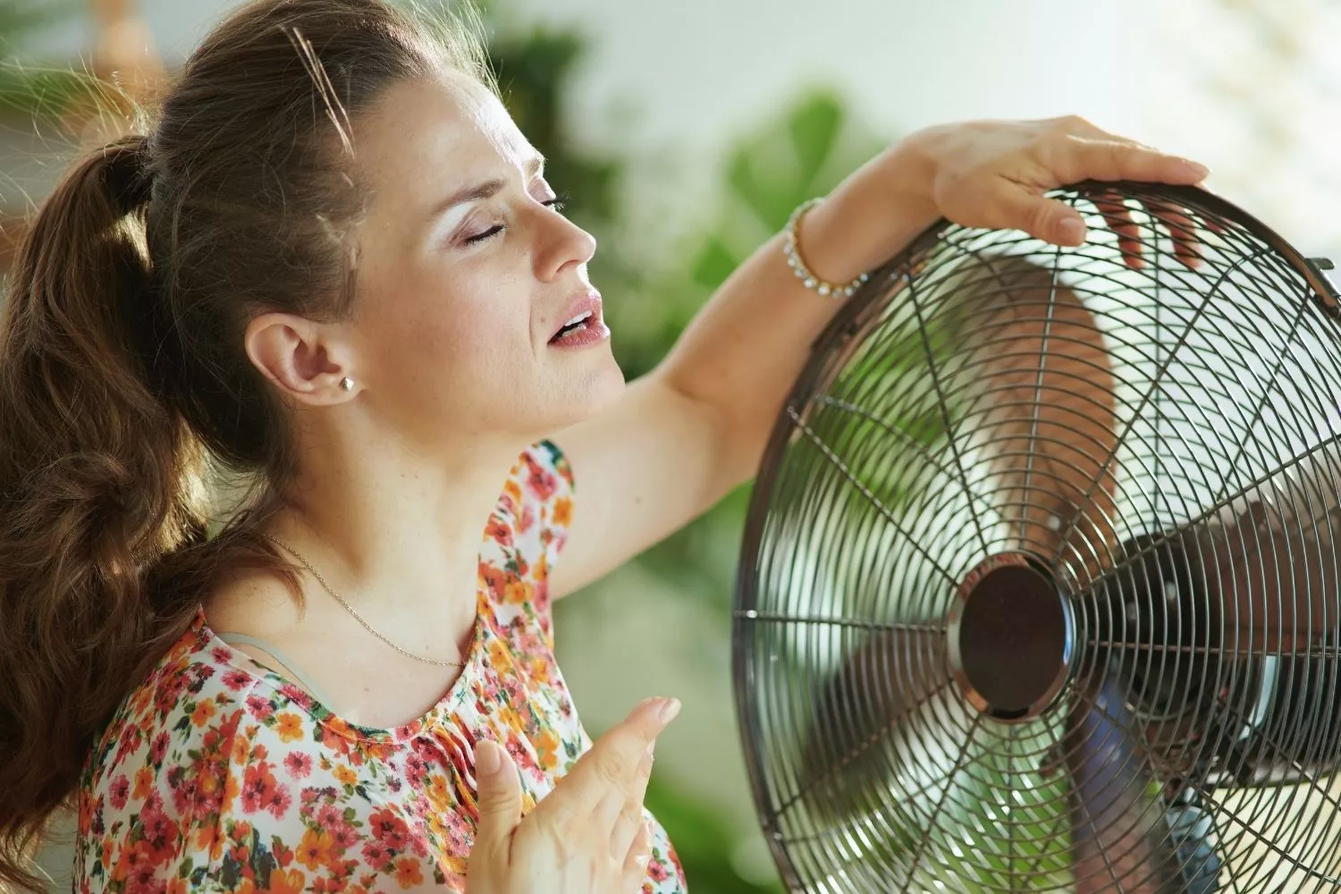 Una persona frente a un ventilador para no pasar calor en casa / CANVA