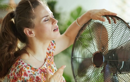 Una persona frente a un ventilador para no pasar calor en casa / CANVA Una persona frente a un ventilador para no pasar calor en casa / CANVA