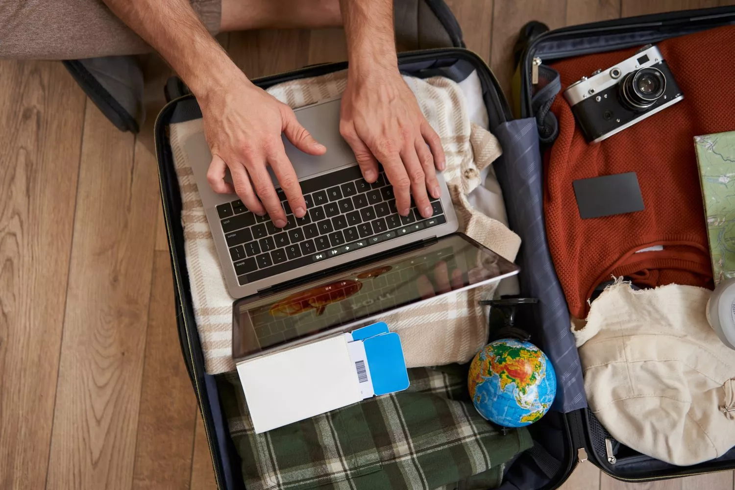 Un chico prepara su equipaje de mano y consulta en Google si puede llevar comida en el avión / FREEPIK