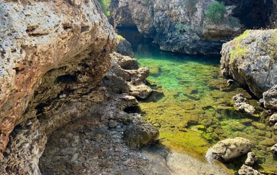 Un banco de piedra y el agua turquesa, como el de una piscina natural, de Cala Rafalet / TEO CAMINO Un banco de piedra y el agua turquesa, como el de una piscina natural, de Cala Rafalet / TEO CAMINO