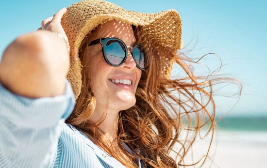 Una persona protege su piel con un sombrero y gafas de sol/ CANVA Una persona protege su piel con un sombrero y gafas de sol/ CANVA