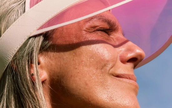Una persona usando visera para protegerse del sol mientras hace deporte/ CANVA Una persona usando visera para protegerse del sol mientras hace deporte/ CANVA