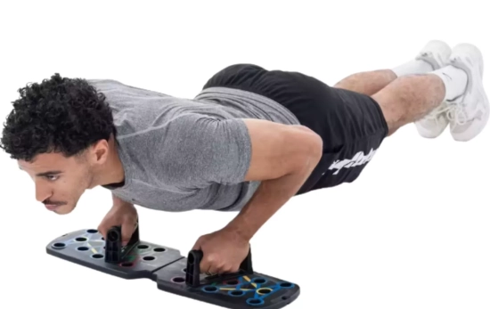 Una persona usando la tabla de flexiones para casa/ DECATHLON Una persona usando la tabla de flexiones para casa/ DECATHLON