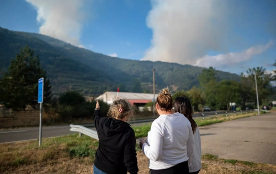 Tres mujeres observan el incendio de León / EP Tres mujeres observan el incendio de León / EP