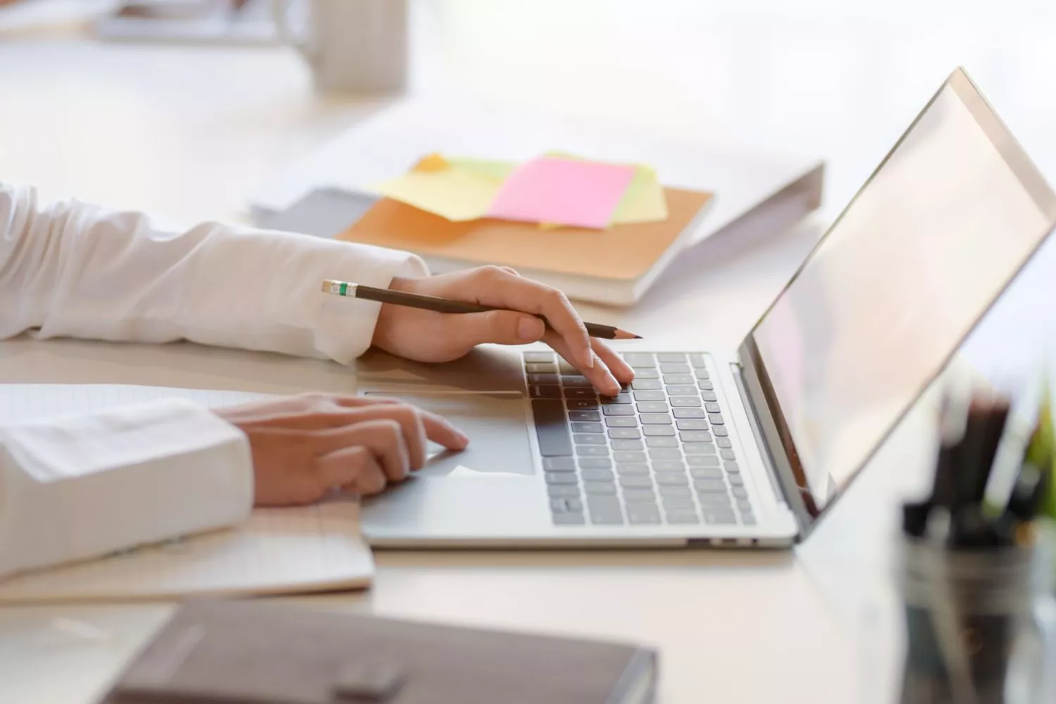 Una persona trabajando en su escritorio que ya conoce  el hábito que te hace más feliz y productivo en casa/ Montaje CONSUMIDOR GLOBAL
