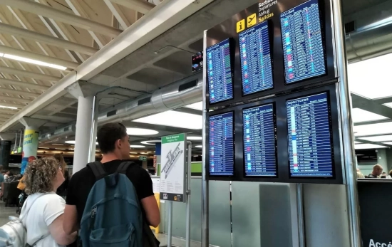 Personas miran los vuelos retrasados y cancelados en el panel de un aeropuerto / ARCHIVO Personas miran los vuelos retrasados y cancelados en el panel de un aeropuerto / ARCHIVO