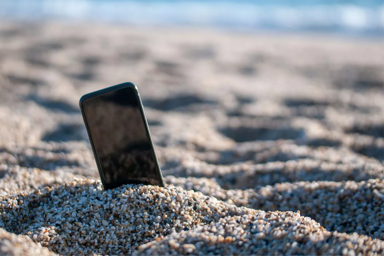 Un móvil perdido en la playa/ CANVA