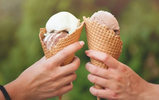 Dos personas comparten un helado en verano/ CANVA Dos personas comparten un helado en verano/ CANVA