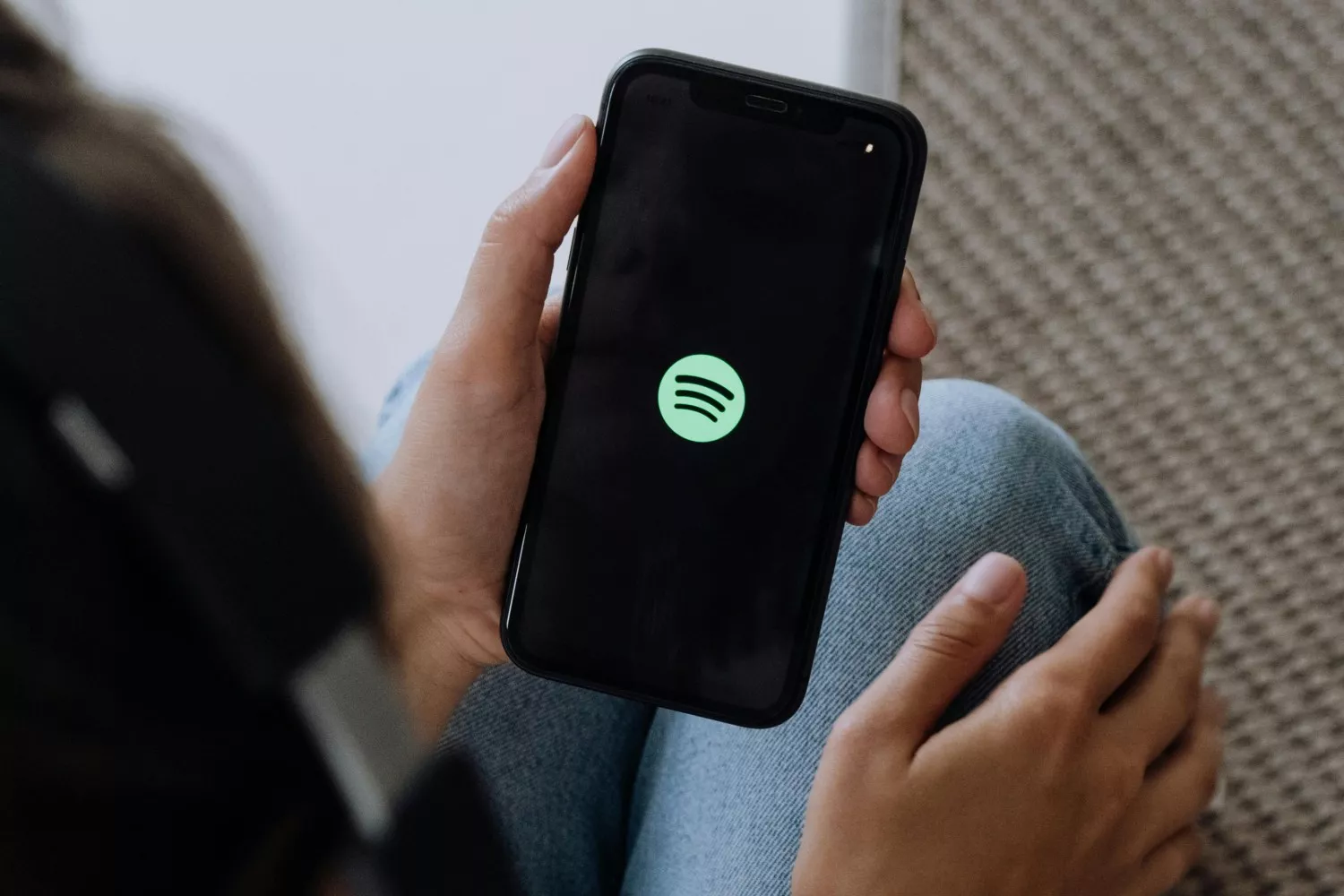Una persona sostiene un móvil con la app de Spotify / PEXELS