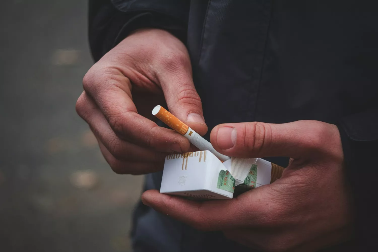 Una persona con un paquete de tabaco   UNSPLASH