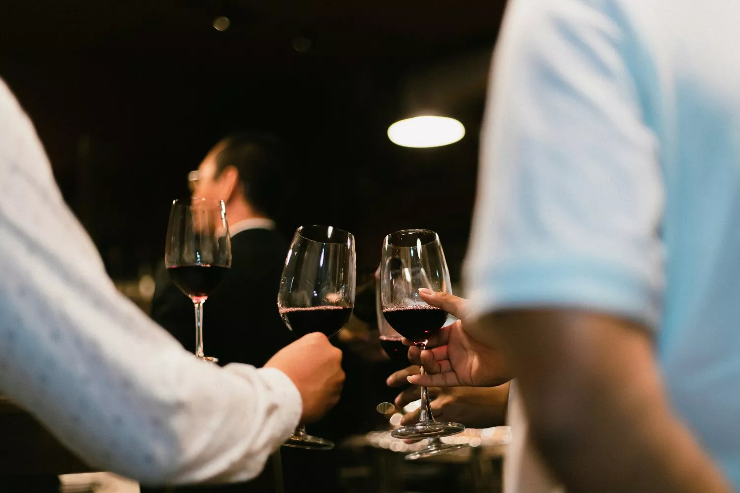 Varias personas brindan con copas de vino tinto / UNSPLASH
