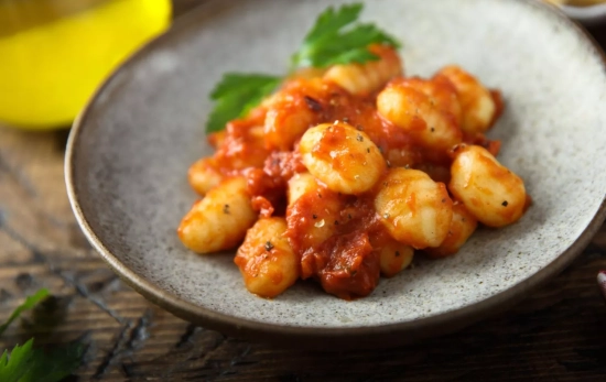 Un plato de ñoquis con pollo y salsa de queso cottage y cherrys/ CANVA Un plato de ñoquis con pollo y salsa de queso cottage y cherrys/ CANVA