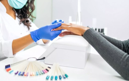 Una manicurista trabajando en un centro de uñas/ CANVA Una manicurista trabajando en un centro de uñas/ CANVA
