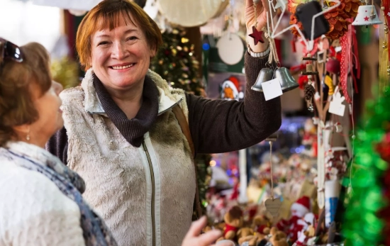 Dos mujeres en un mercadillo navideño/ CANVA Dos mujeres en un mercadillo navideño/ CANVA