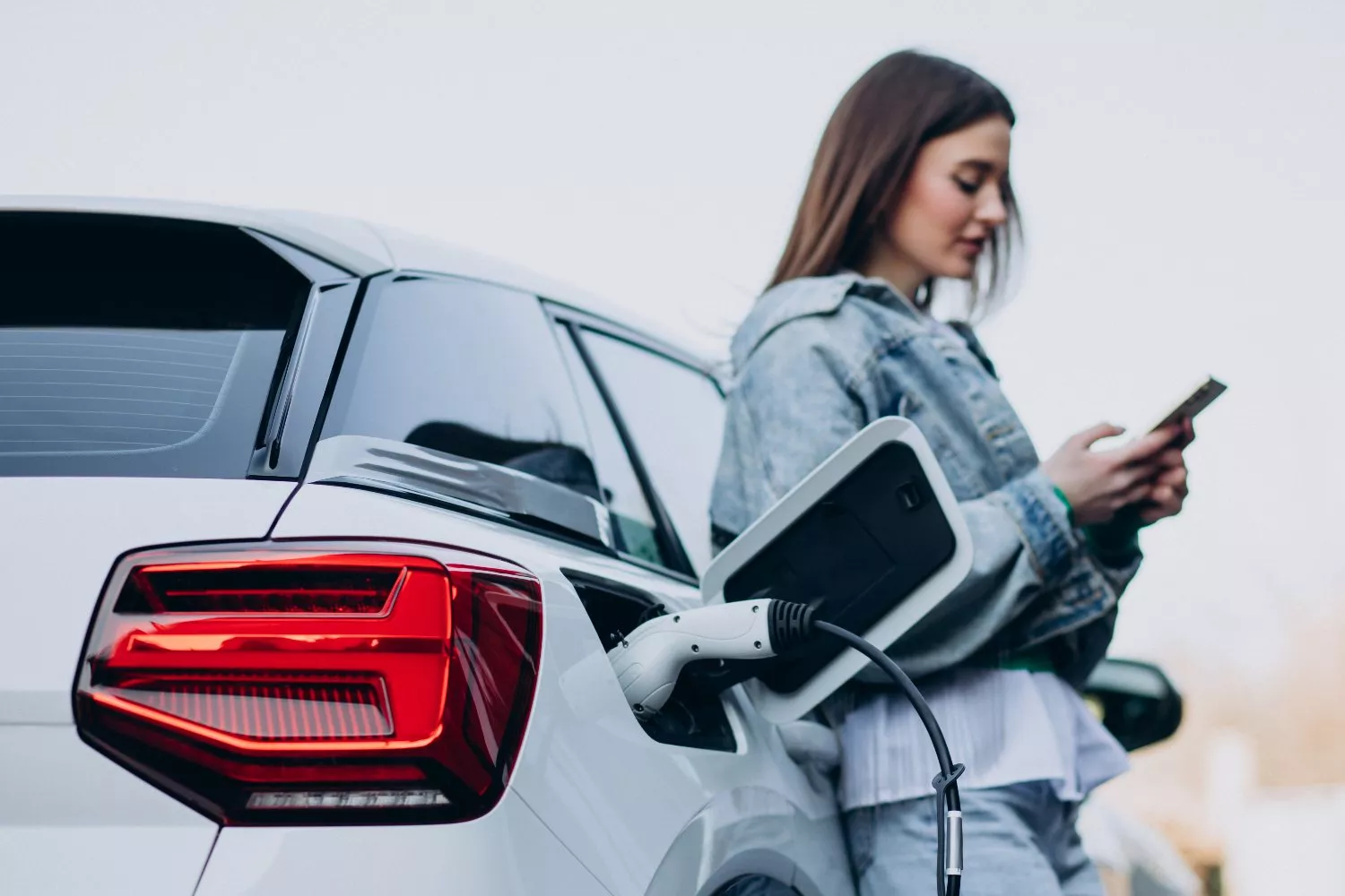 Una conductora carga su coche eléctrico / FREEPIK - senivpetro