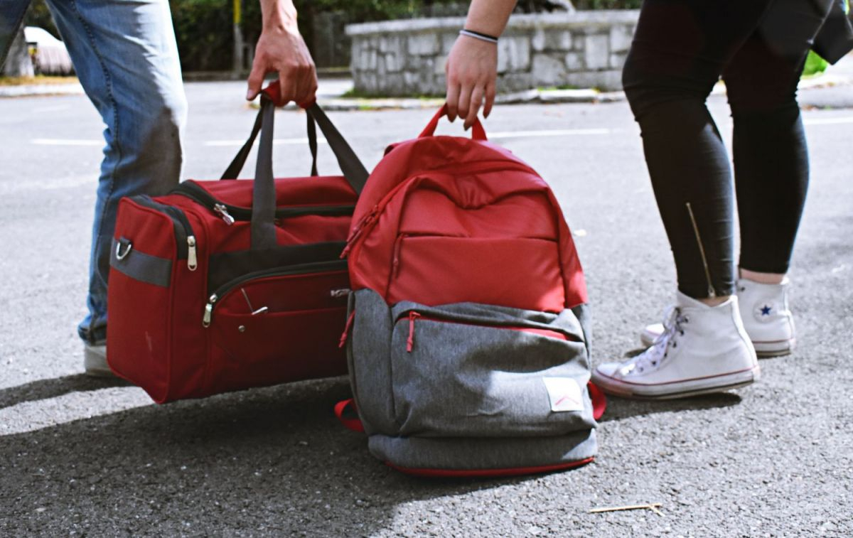 Dos personas cargan sus bolsas de viaje / PEXELS
