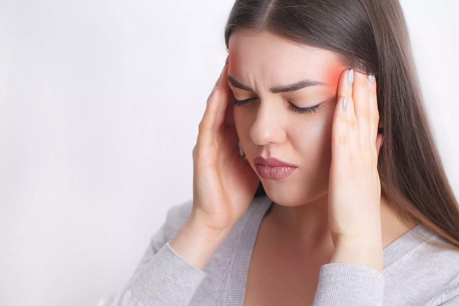 Una chica con migrañas que desconoce que puede ser un signo de alerta en su salud/ CANVA