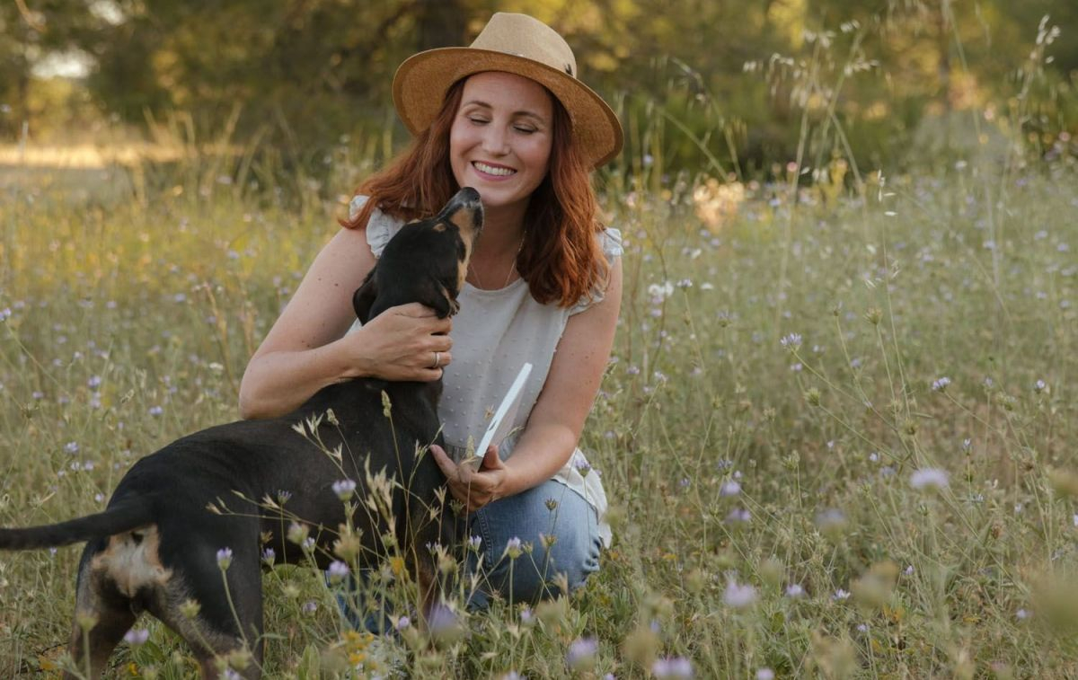La auxiliar de veterinaria y escritora Laura Vidal con un perro en el campo