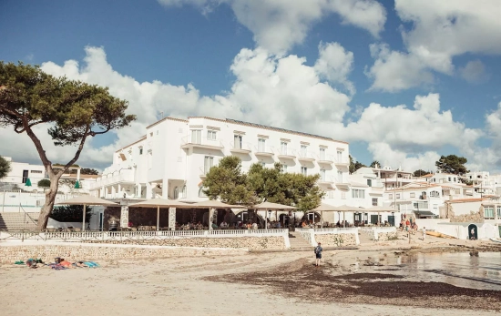 La playa, el hotel y algunas casas del pueblo de Alcaufar / HOTEL XUROY La playa, el hotel y algunas casas del pueblo de Alcaufar / HOTEL XUROY