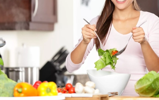 Una persona haciendo una ensalada/ CANVA