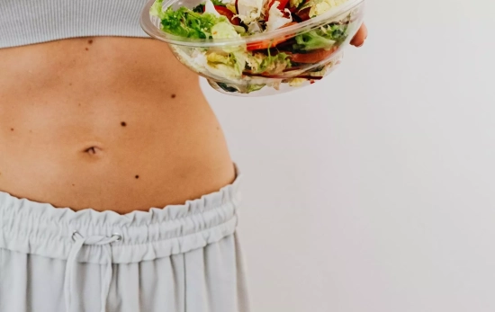 Una persona comiendo una ensalada/ CANVA