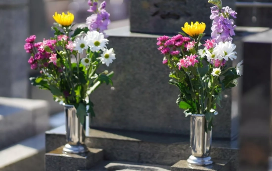 Dos ramos de flores en una lápida/ CANVA Dos ramos de flores en una lápida/ CANVA