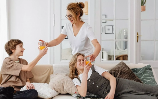 Una madre dando de merendar a su hija y su amigo/ CANVA Una madre dando de merendar a su hija y su amigo/ CANVA