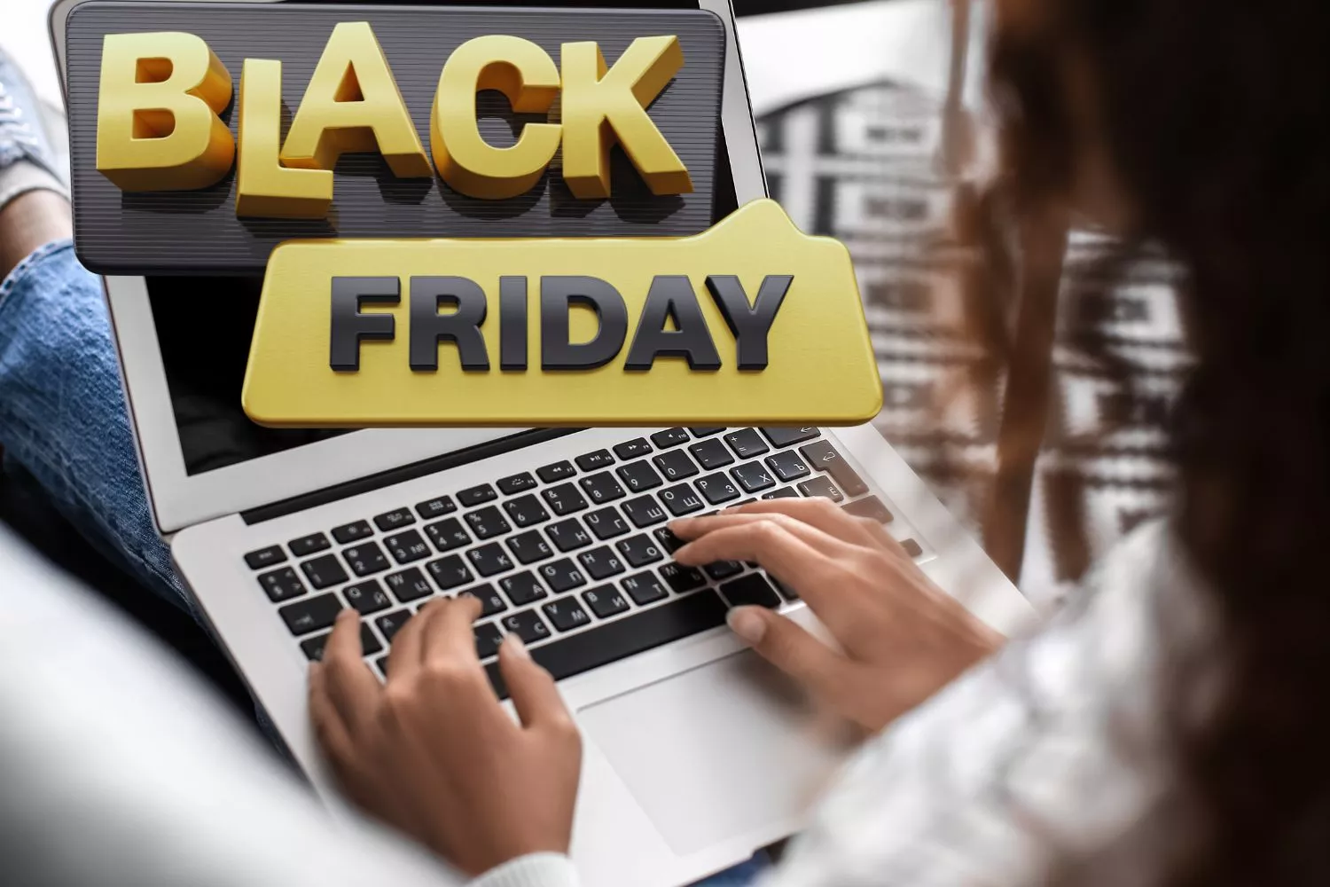 Un rótulo del Black Friday y una persona con el ordenador / Montaje CONSUMIDOR GLOBAL